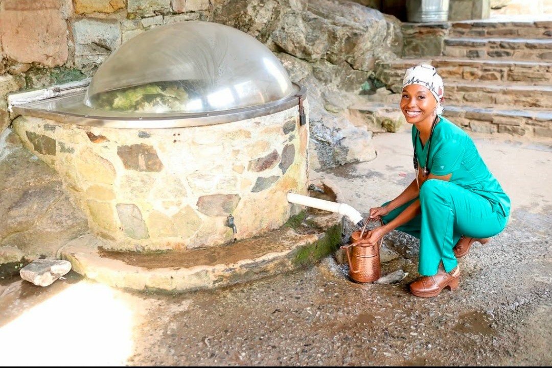 Yuneka Korunn gathering spring water in a copper vessel